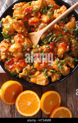 Delicious orange chicken fillets close-up on a plate on the table. vertical view from above