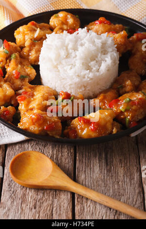 Orange chicken fillet with sauce and rice closeup on a plate. Vertical Stock Photo