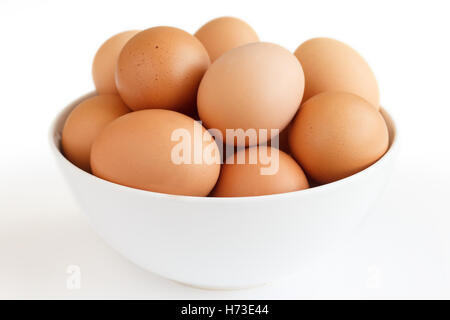 Large white bowl bowl af chicken eggs on white Stock Photo