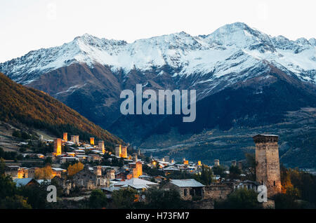 View of the Svanetian towers with night illumination in Mestia village at sunrise. Upper Svaneti, Georgia. Stock Photo