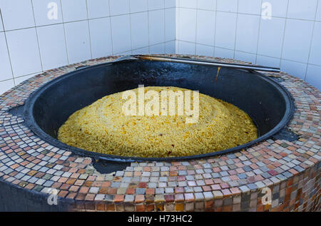 The rice is cooked in broth (zirvak) for the pilaf in Center Asian Plov Center Stock Photo