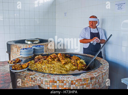 The chef next to the pilaf cauldron (qozon) in open air kitchen of Center Asian Plov Center Stock Photo