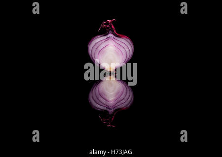 Half red onion isolated on black reflective background Stock Photo