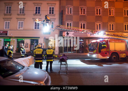 Munich, Germany. 02nd Nov, 2016. A firefighter transports a dead body on a gurney from a ladder at a deployment site in Munich, Germany, 02 November 2016. Three people were killed and ten other inured in a fire on Dachauer-Strasse. Photo: TOBIAS HASE/dpa/Alamy Live News Stock Photo