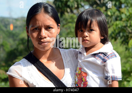 Silvia Shiguango of the indigenous Huaorani tribe stands with her young son Joel near an oil production site in the city that lives off oil, Coca, Ecuador, 22 October 2016. Because of the dropping of prices many have lost their occupations. The environmental encyclica of pope Franics 'Laudato Si' has been activated for more than a year - but in how far does it function practically? Visiting the Amazonian rainforest reminds us how difficult the fight is. Photo: Georg Ismar/dpa Stock Photo
