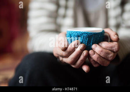 Elderly woman holding cup of hot coffee or tea Stock Photo