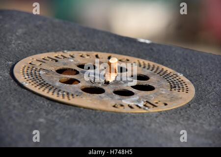 An outdoor street ashtray with a cigarette stub on top UK Stock Photo