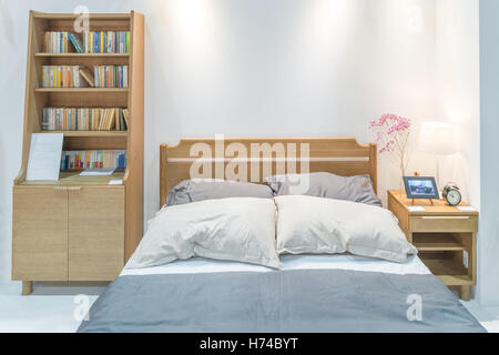 Modern bedroom interior with wooden bed and bookshelf in bedroom. Japanese style bedroom. Stock Photo