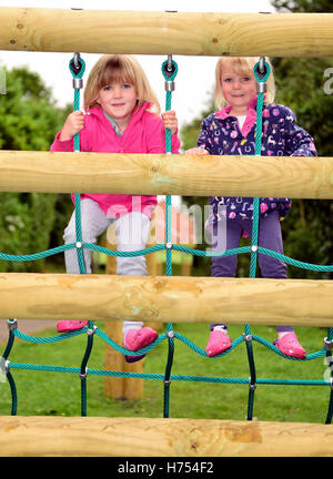 Two youngsters (6 and 3 years) using playground facilities, Four Marks, near Alton, Hampshire, UK. Stock Photo