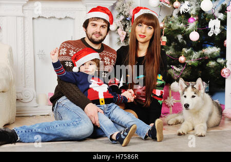 young family sitting under the Christmas tree Stock Photo