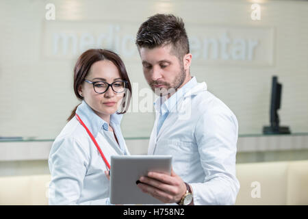 Two cheerful doctors using a digital tablet. Stock Photo