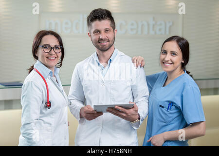 Three doctors using a tablet in bright office Stock Photo