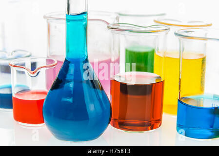 Beakers, flask and test tubes with different types of oil on grey ...