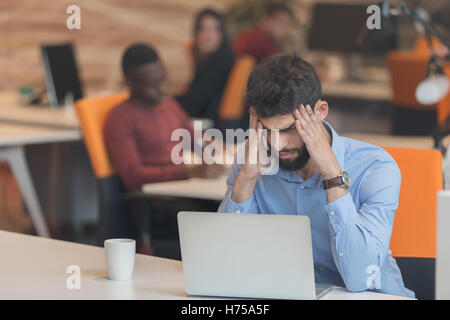 Software Developer sitting with laptop computer in startup office Stock Photo