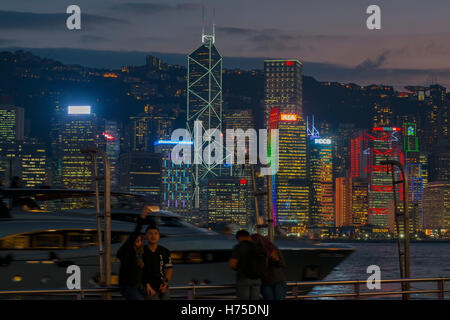 The famous Tsim Sha Tsui promenade, and tourists enjoying the evening view of Hong Kong Island, Hong Kong, China. Stock Photo