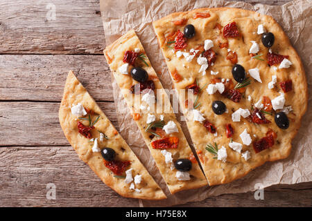 Focaccia with dried tomatoes, feta and olives on the table. horizontal view from above Stock Photo