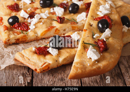 Focaccia with dried tomatoes, feta and olives on the table. macro horizontal Stock Photo
