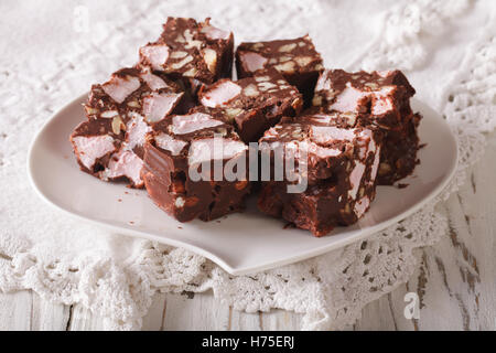 Chocolate cake Rocky road with marshmallow and nuts close-up on a plate on the table. horizontal Stock Photo