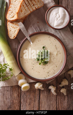 Cauliflower cream soup and ingredients close-up on the table. vertical view from above Stock Photo