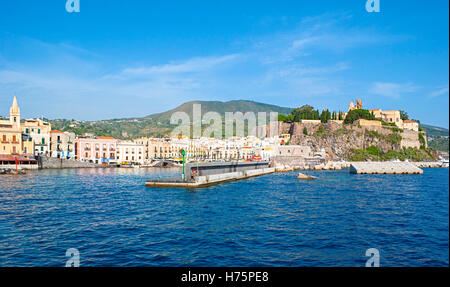 The yacht approaches the port of Marina Corta with the fortress Castello, that defends the harbour since medieval period, Lipari Stock Photo