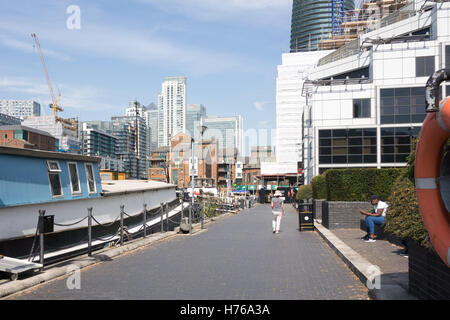 LONDON, UNITED KINGDOM - AUGUST 24TH 2016: City workers relaxes along the dock of Oakland Quay in Crossharbour. Stock Photo