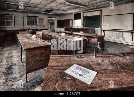 Chemistry lab in abandoned school still with pupil's drawing on bench in foreground. HDR. Stock Photo