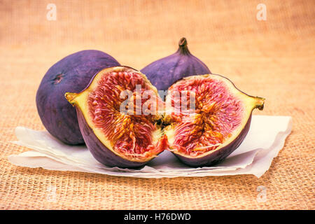Three ripe figs on baking paper background, close up Stock Photo