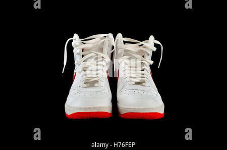 Pair of high-top classic white leather basketball shoes sneakers with isolated on black Stock Photo