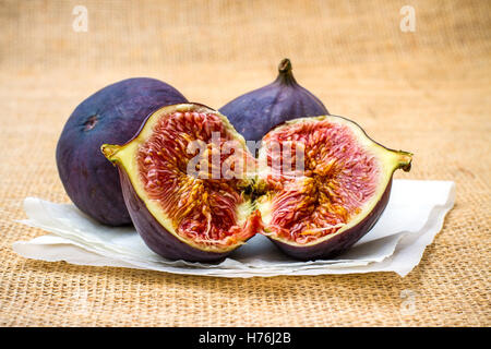 Three ripe figs on baking paper background, close up Stock Photo