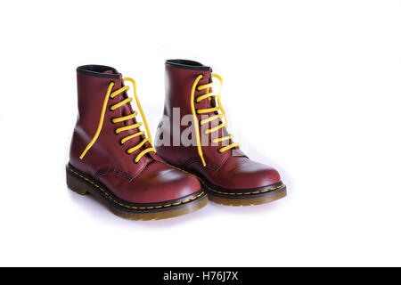 A pair of 8 eyelet 8 inch classic unisex cherry red oxblood lace-up fashion combat boots with yellow laces Stock Photo