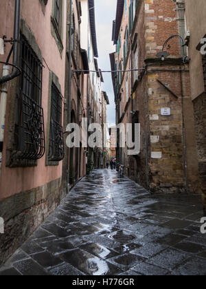 Narrow street in the old town on a rainy day. Lucca, Tuscany, Italy. Stock Photo