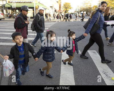 Hispanic mother and children cross the street after shopping in commercial area in the Bensonhurst section of Brooklyn in NY. Stock Photo