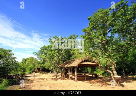 Small old wooden hut with green trees against blue sky background at Phu Phra Bat Historical Park, Udonthani, Thailand Stock Photo