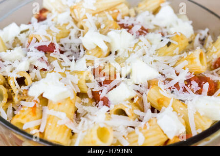Baked tortiglioni pasta with tomato sauce, mozzarella cheese and parmesan cheese in glass bowl Stock Photo