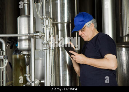 skilled worker fitting a pump plant in a industrial company Stock Photo