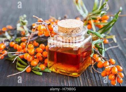 Seabuckthorn oil bottle with berries branches Stock Photo