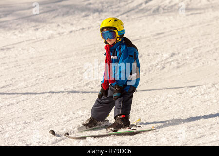 Cute little boy, skiing happily in Austrian ski resort in the mountains, wintertime Stock Photo