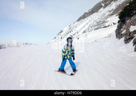 Cute little boy, skiing happily in Austrian ski resort in the mountains, wintertime Stock Photo