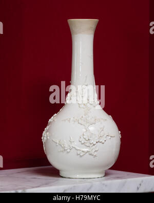 White oriental blossom vase on marble mantlepiece set against red wall in palladian 18th century Dumfries house, Ayrshire, Scotl Stock Photo