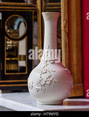 White oriental blossom vase on marble mantlepiece set against red wall in palladian 18th century Dumfries house, Ayrshire, Stock Photo