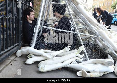 Two protesters inside a structure chained to the gates of the Russian embassy in London where 25 activists from two campaign groups The Syria Campaign and Syria Solidarity UK have scattered over 800 limbs around the entrance in a protest at the bombing of civilians in east Aleppo. Stock Photo