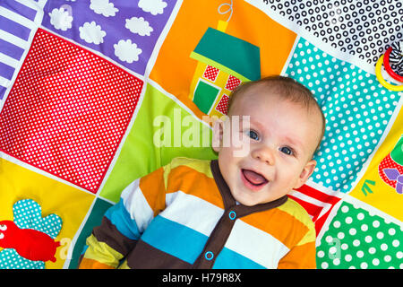 Baby boy playing on a play mat