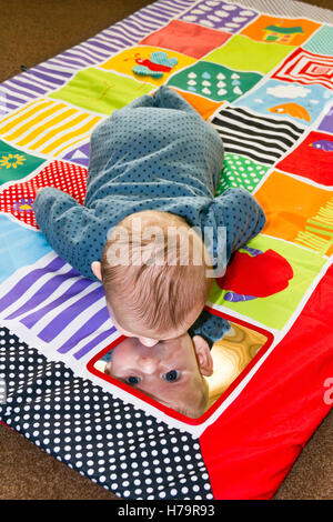 Baby boy playing on a play mat