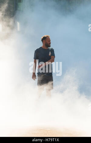 London Southbank Tate Modern water mist work of art feature young man male stands in mist Stock Photo