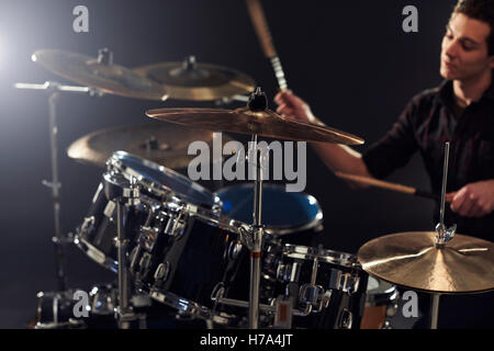 Side View Of Young Drummer Playing Drum Kit In Studio Stock Photo