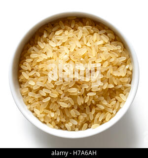 Bowl of short grain parboiled rice isolated on white from above. Stock Photo