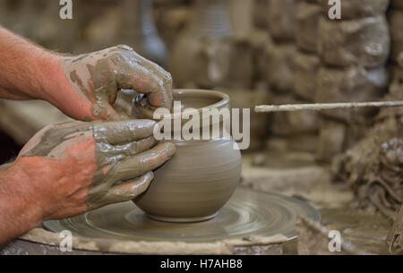 Hands working on pottery wheel in workshop Stock Photo