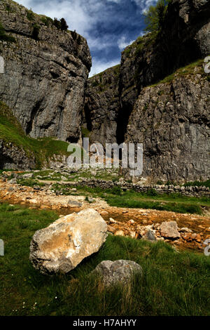Portrait Gordale Scar on sunny day at Malham in the Yorkshire Dales showing the central waterfall and river from the entrance to the amphitheater. Stock Photo