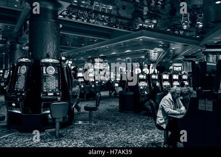 Men sit gambling at slot machines, Foxwoods Resort Casino interior, Ledyard, Connecticut, USA Stock Photo