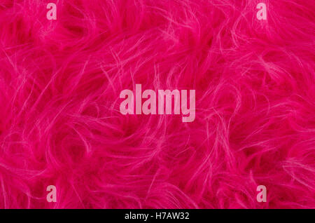 Pink plush fabric. Very soft polyester textile made of synthetic fibers with long hairs. Macro close up material photography. Stock Photo